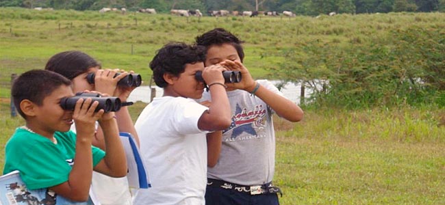 Costa Rican students try out binoculars while bird watching