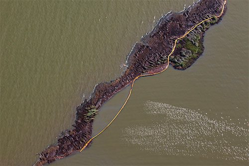 Oil booms remain our best defense against oil washing ashore, but they were designed to be used on flat water and are quickly overwhelmed by ocean waves. On many islands and marshes, the protective booms served only to mark how far oil had washed onto shore, as in this aerial photograph.