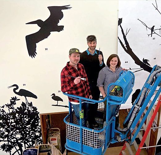 Artist James Prosek recently painted a mural titled Wall of Silhouettes in the Cornell Lab’s visitor center. Photo by ; DIANE TESSAGLIA-HYMES.