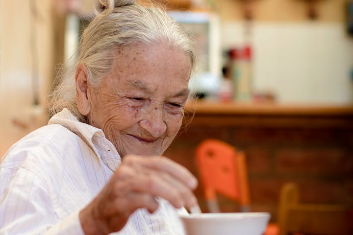 Una mujer disfruta de un pintado (café con un chorrito de leche) en un café en el pueblo de Andes.