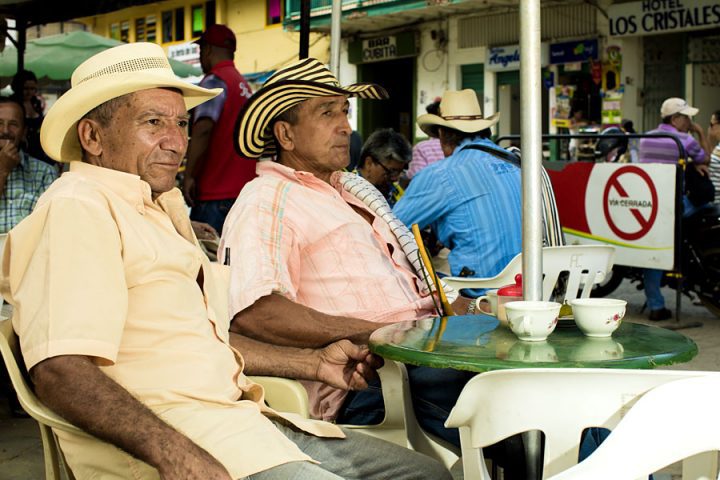 Los locales disfrutan de un tinto (café negro) por la tarde en la plaza del pueblo de Andes.