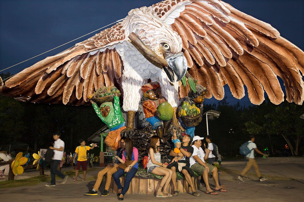 Families gather under the statue of a Philippine Eagle at the People’s Park in downtown Davao City. Photo by Kike Arnal.