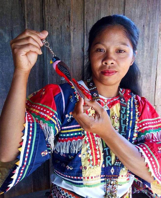 An Arakan Manobo woman shows off a plush Philippine Trogon key chain she made. She earns a salary from her work while helping raise funds for Philippine Eagle conservation. Photo courtesy of the Philippine Eagle Foundation.