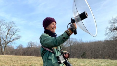Valerie Heemstra holding a parabolic microphone in field