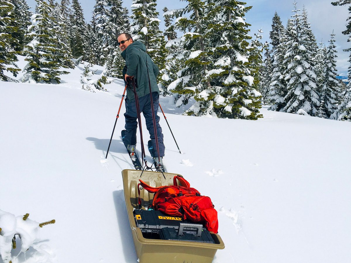 a researcher skis toward a study site pulling a sled of equipment